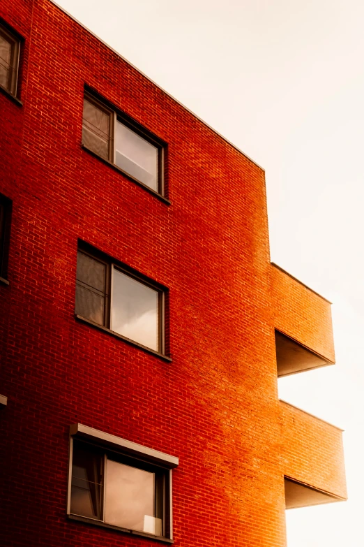 the red wall of a modern building with four windows