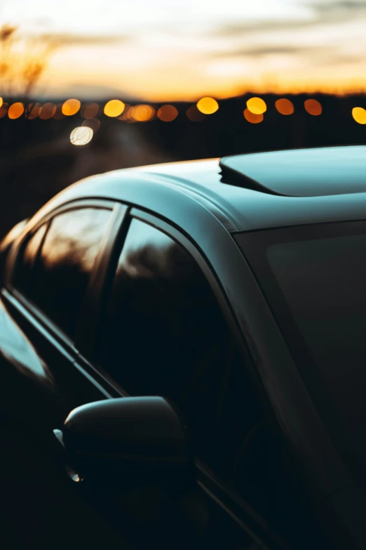 a car parked near a field with a sunset