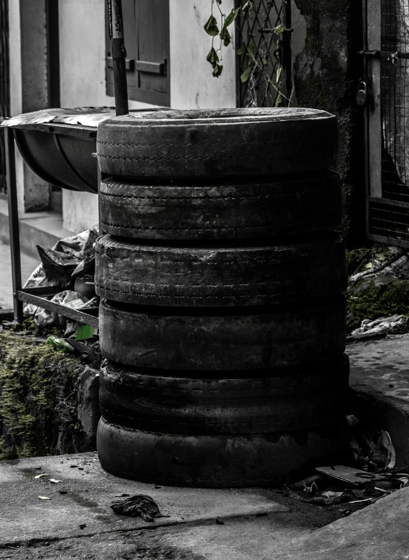 a large stack of tires with some plants in it