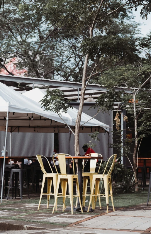 a group of chairs sitting outside with tables