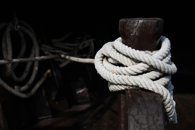 a white rope wrapped around a pole on the deck