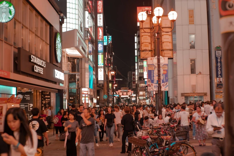 a group of people walking on the street next to businesses