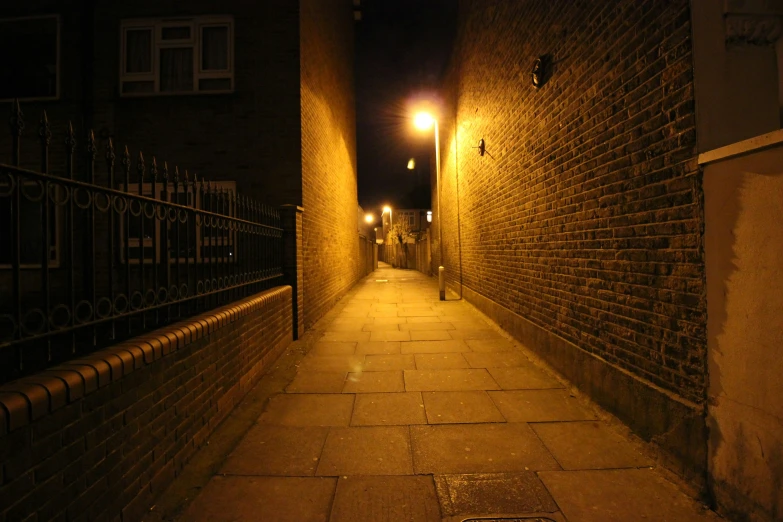 a night time view down an alley way of brick buildings