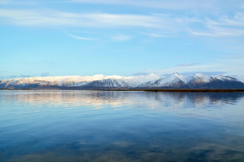 a small boat is in the middle of a lake surrounded by mountains