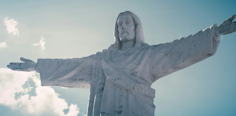 a picture of a statue looking up with a sky background