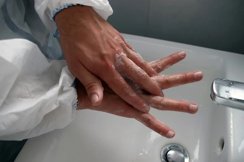 a person with their hand under a sink