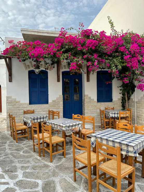 the patio area at a restaurant with wistering flowers growing up it's roof