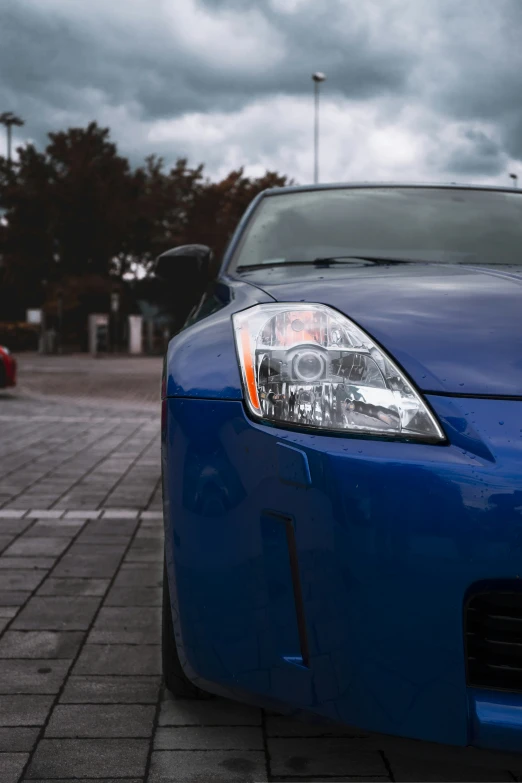 the back of a blue car parked on a road with a parking meter