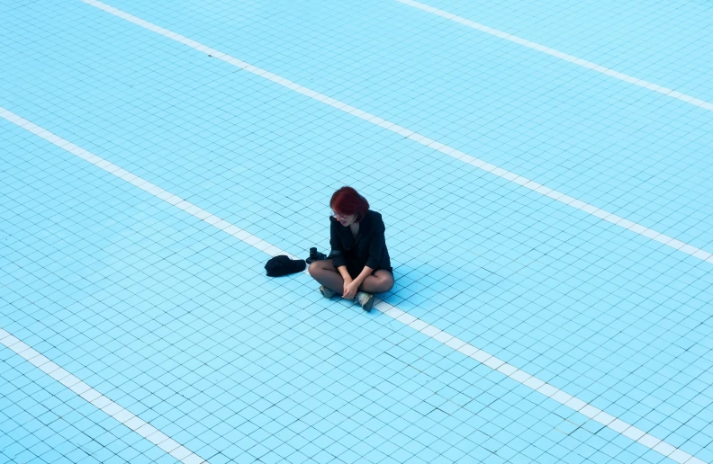 a person kneeling on a blue tiled floor