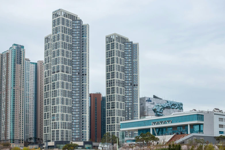 two very tall buildings are in the middle of a park