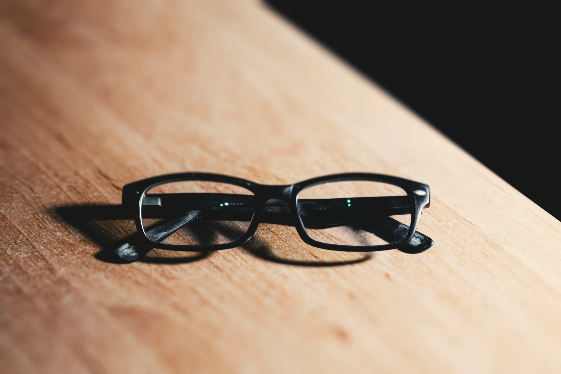 the black pair of glasses sits on the edge of the counter