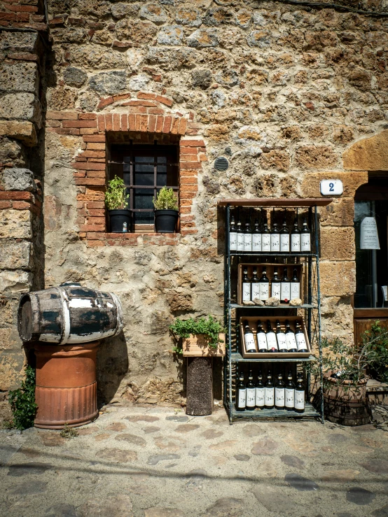 a brick building with two windows and a wine case sitting outside