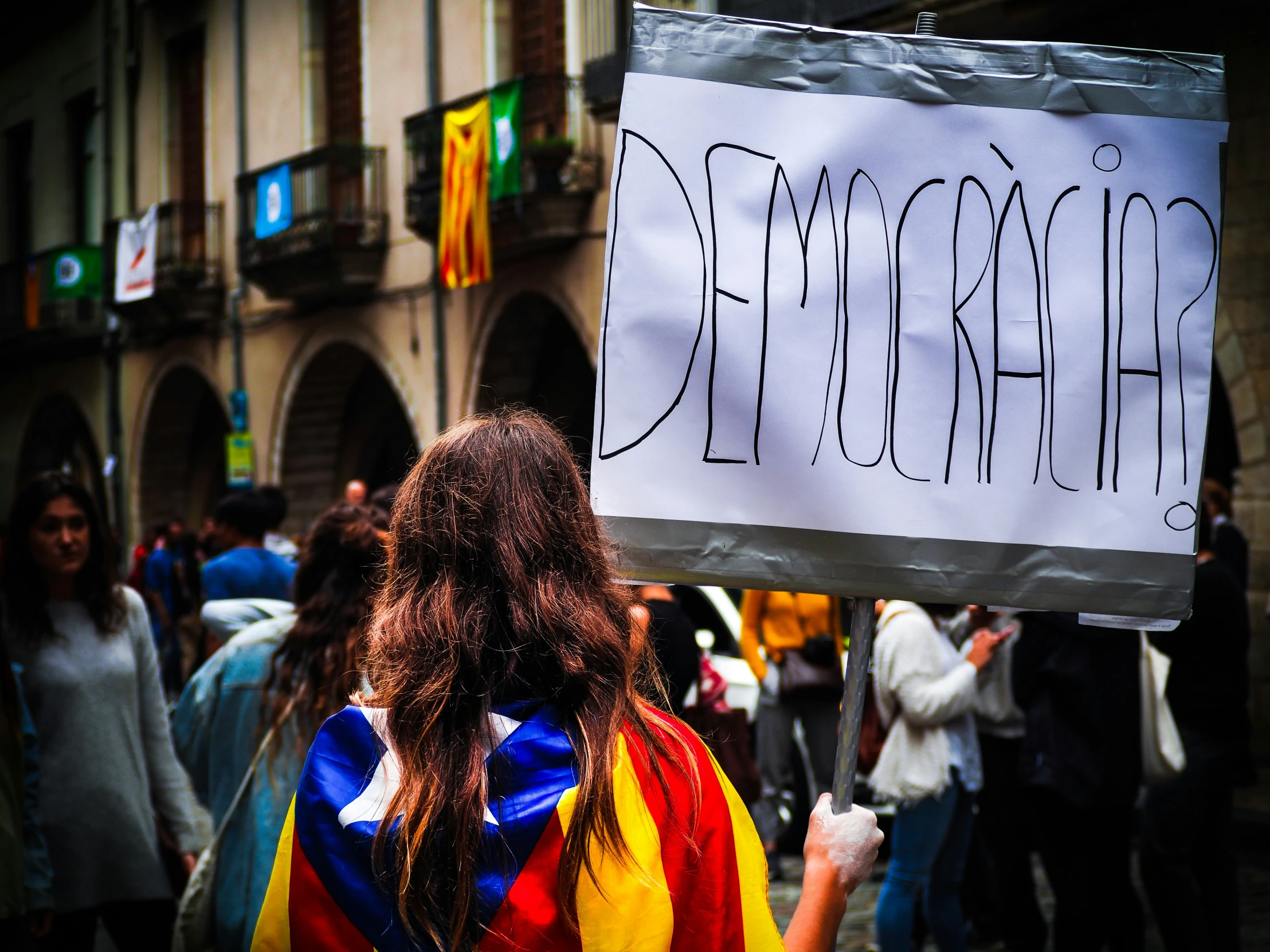 the woman is holding a sign and flags