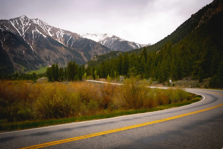 an open road going through the middle of mountains