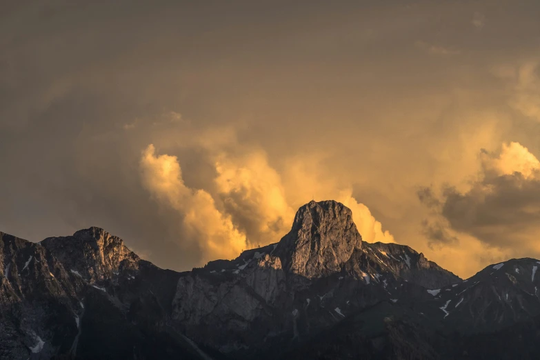 the mountains are silhouetted against a cloudy sky