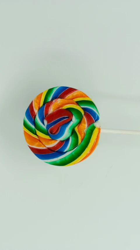 a lollipop is being held by a long white stick