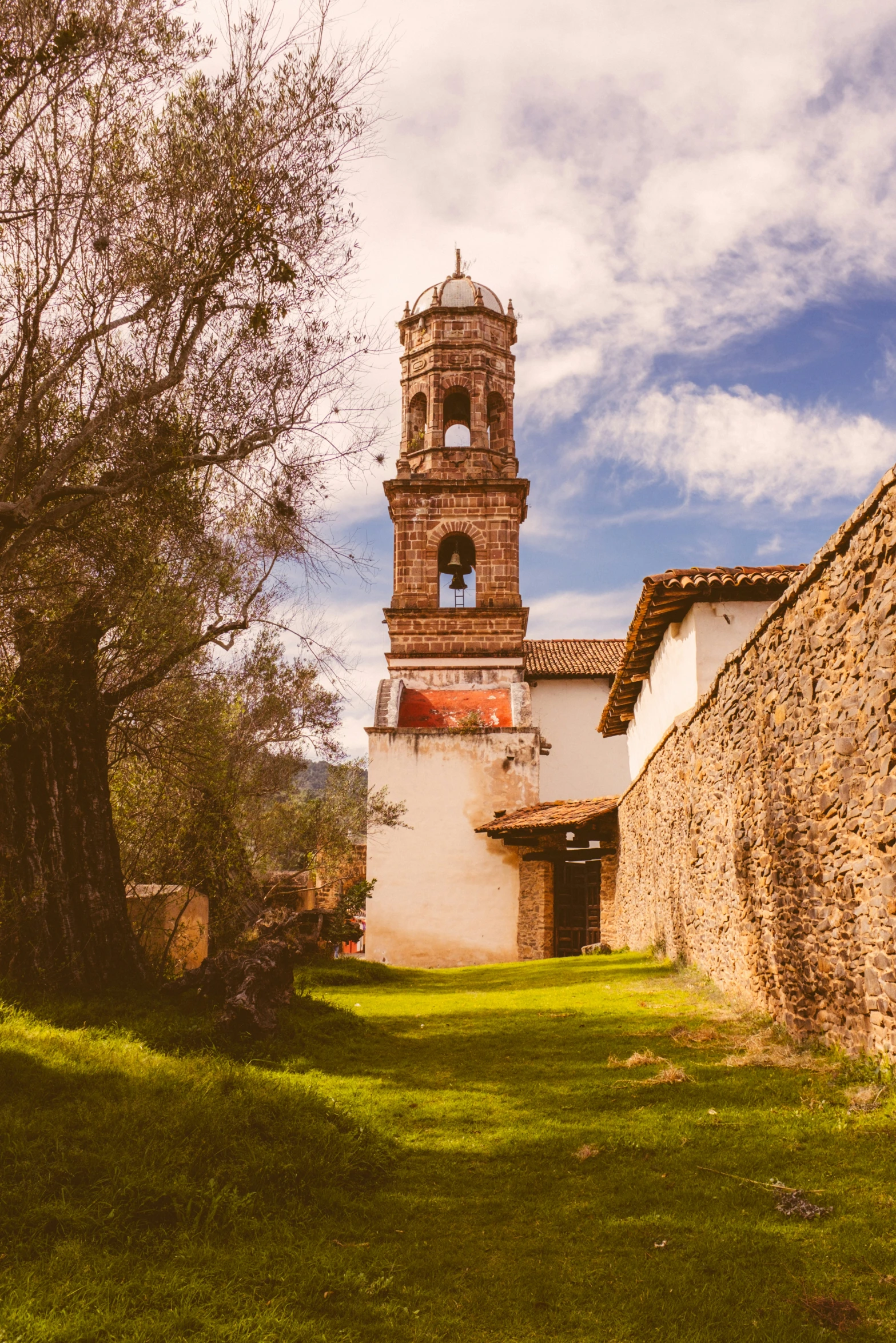 an old fashioned building next to a tree