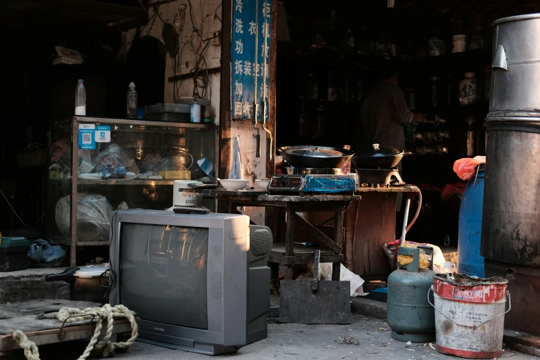 a television and old soda cans are outside on a rainy day