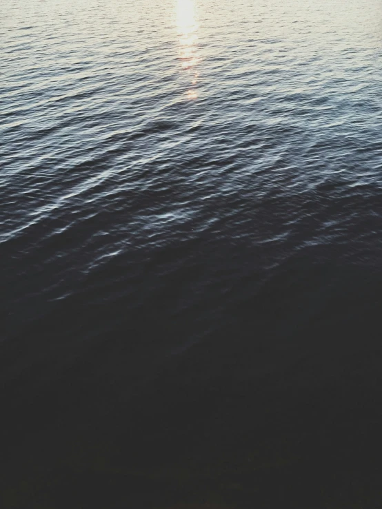 a person standing in the ocean near water