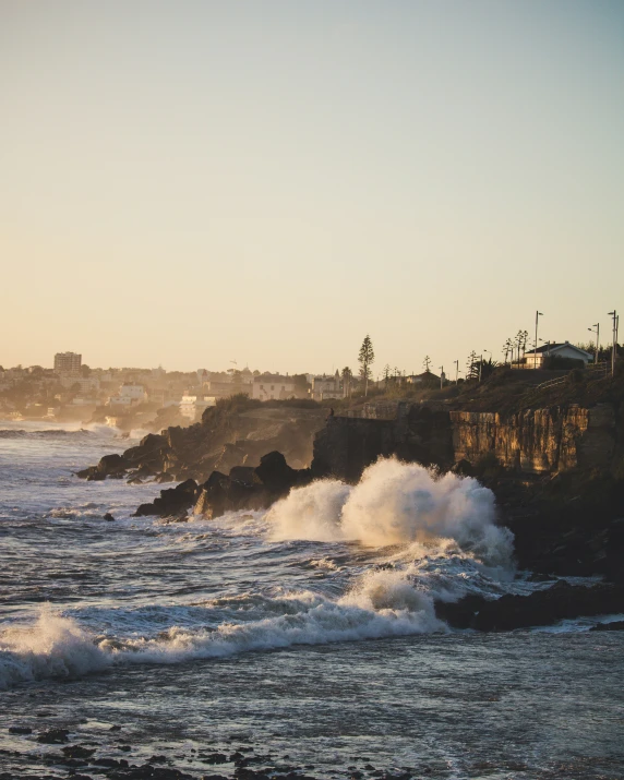 a large wave hitting against the cliffs and the ocean