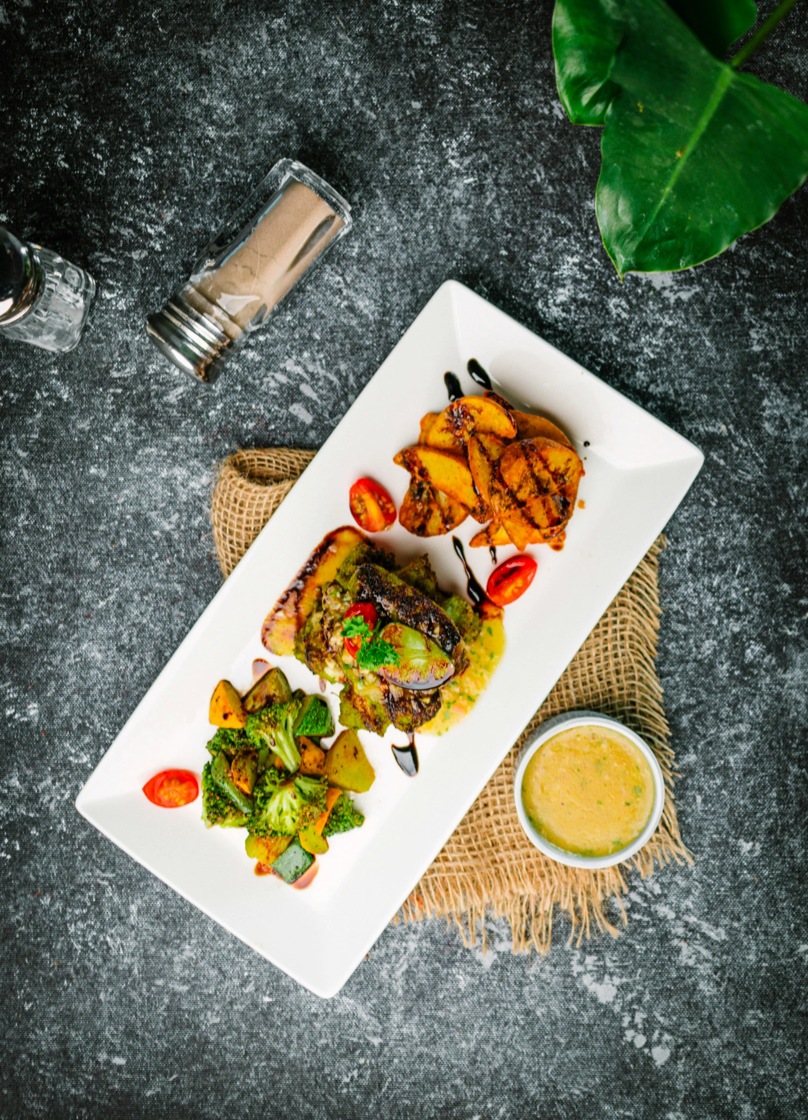 a white plate filled with some veggies next to a side of sauce