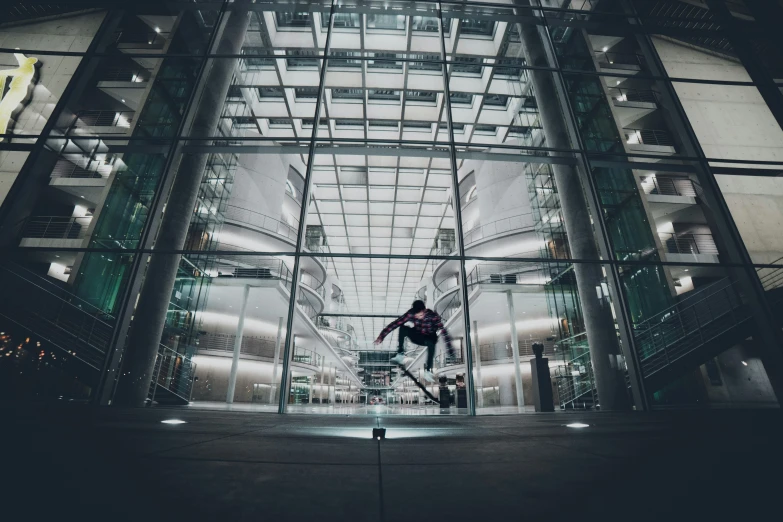 a man riding a skateboard down the side of a glass building