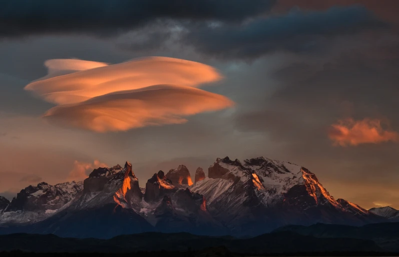 the clouds over the mountains are colorful and interesting