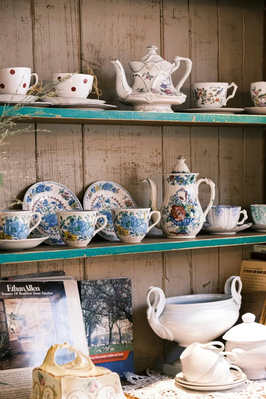 a display filled with china on wooden shelves