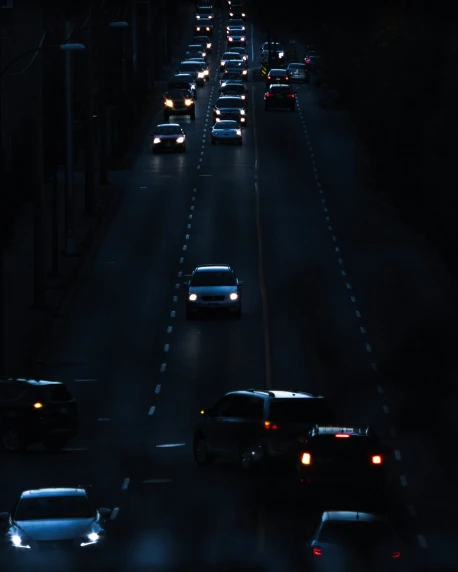 several cars are seen driving down the busy highway at night