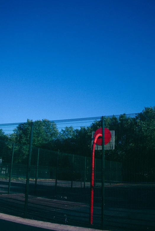 there is a red traffic signal behind the gate