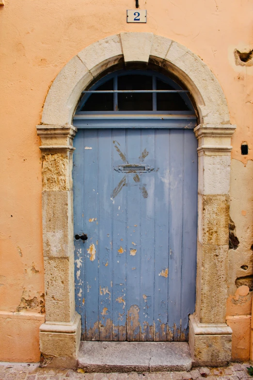 a very blue door in the front of a yellow wall