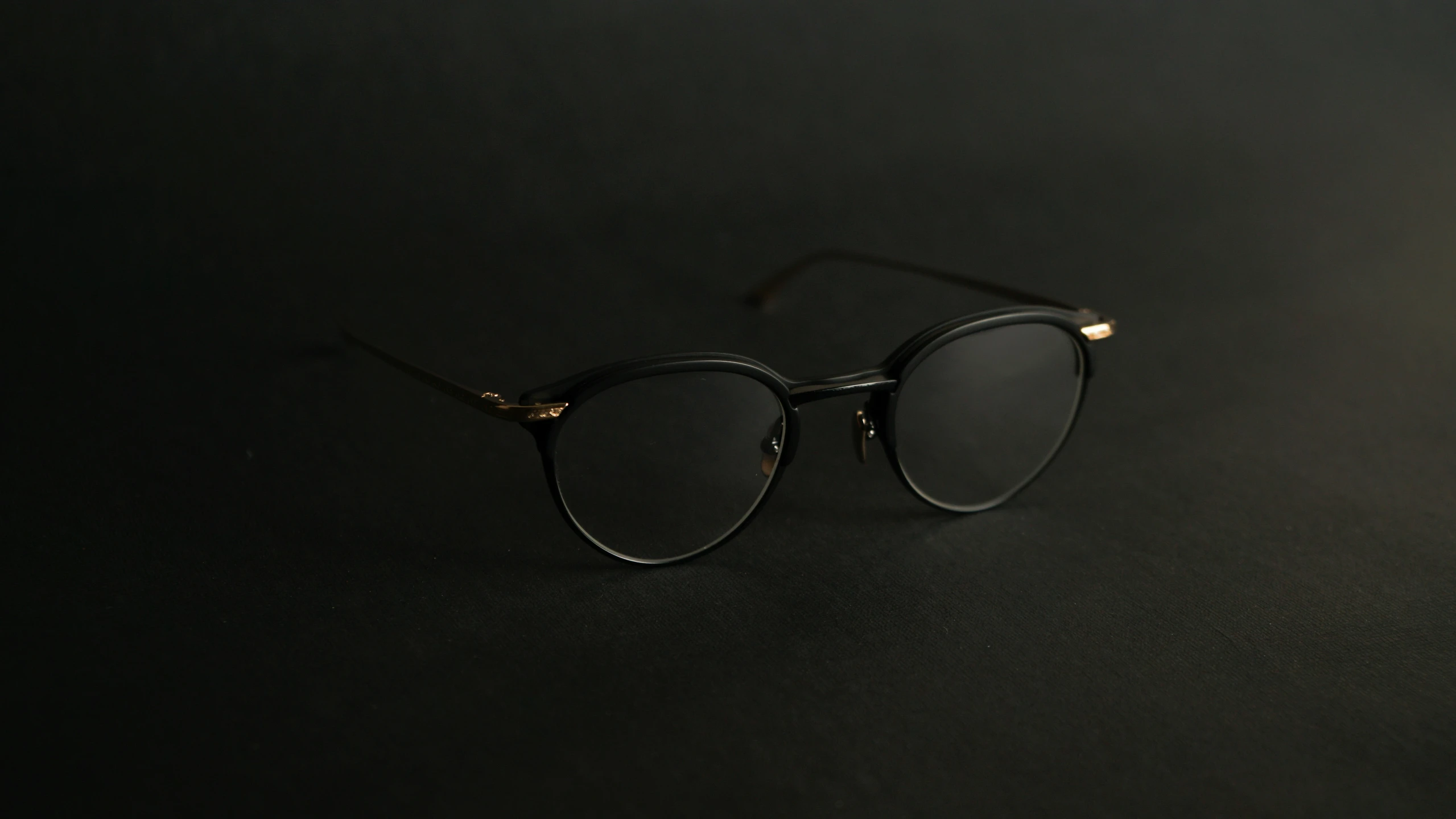 a pair of eyeglasses sitting on top of a black table