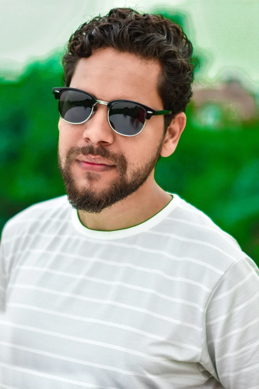 a young man with a goatee and dark glasses