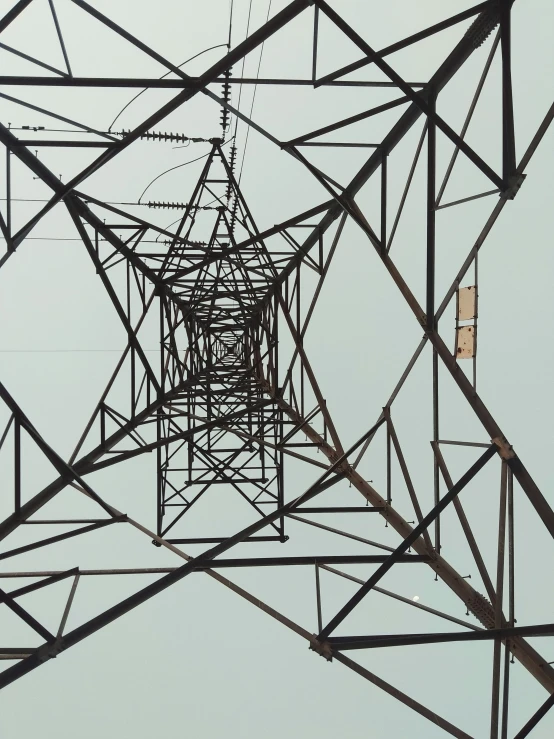 electrical structure with many wires overhead on a cloudy day