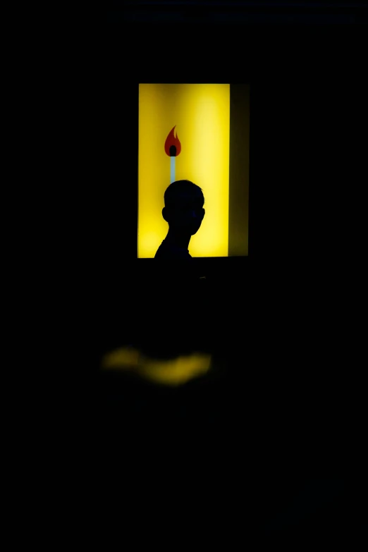 a person sitting in a room with a lit candle