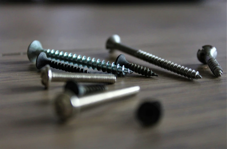 there are screws and nuts scattered on the wooden floor