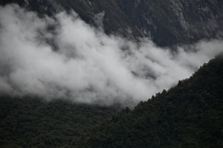 some very tall mountains are covered with thick clouds