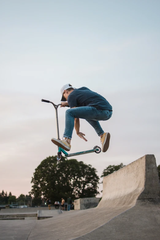 a man in the air doing a trick on his scooter