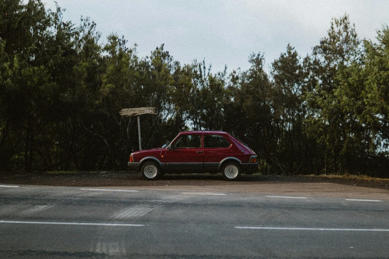 a red car parked next to a street lamp