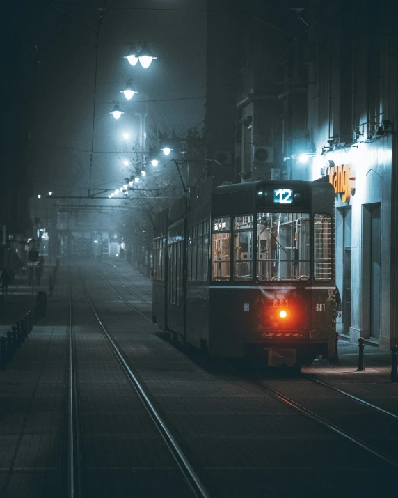 an old - fashioned tram on the tracks at night