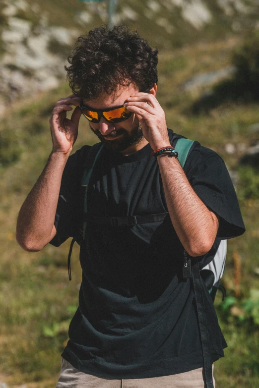 a man wearing sunglasses in the mountains by some trees