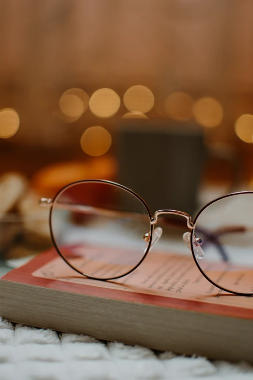 pair of glasses sitting on top of an old book