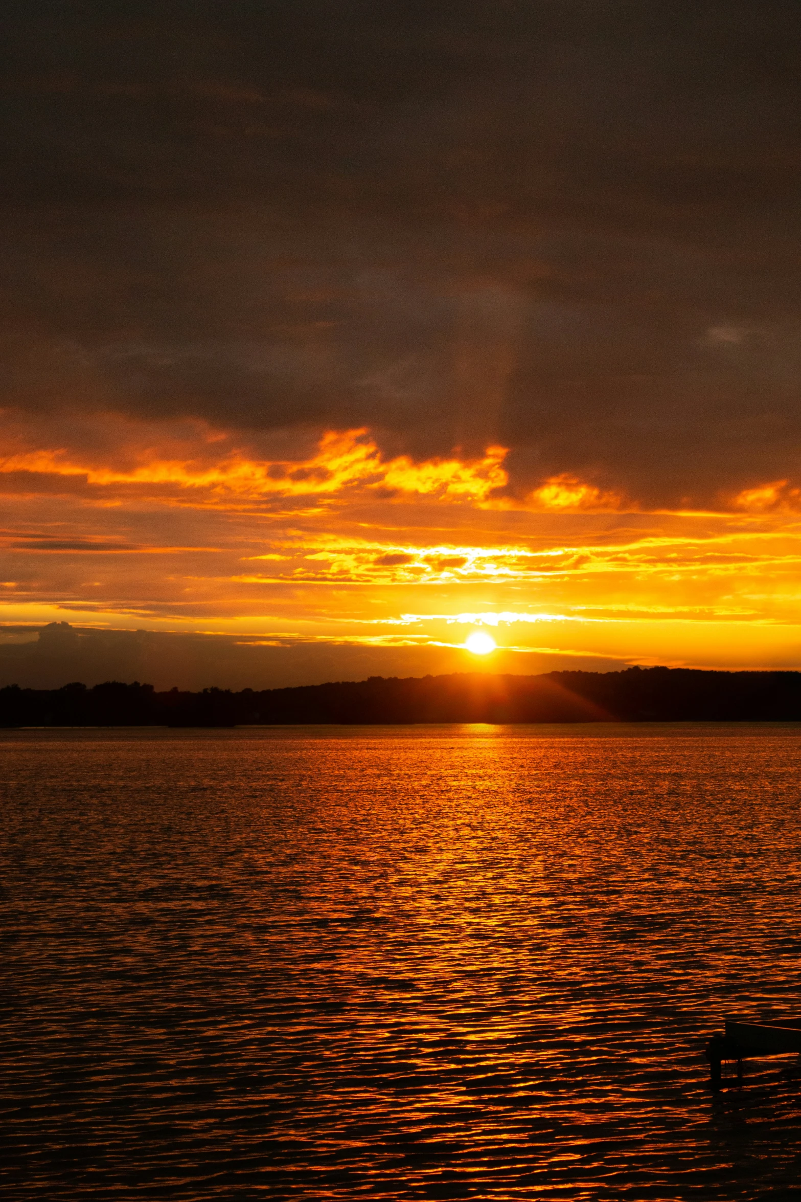 a boat sitting on top of a lake at sunset