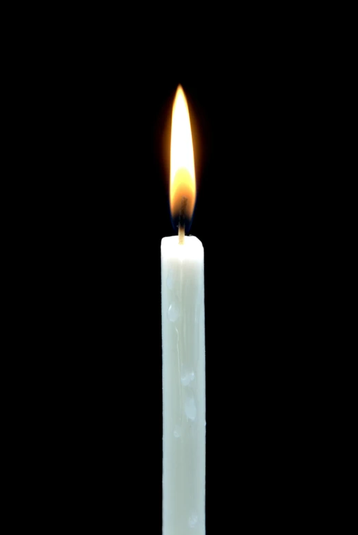 a lit candle that is white and with a brown tip