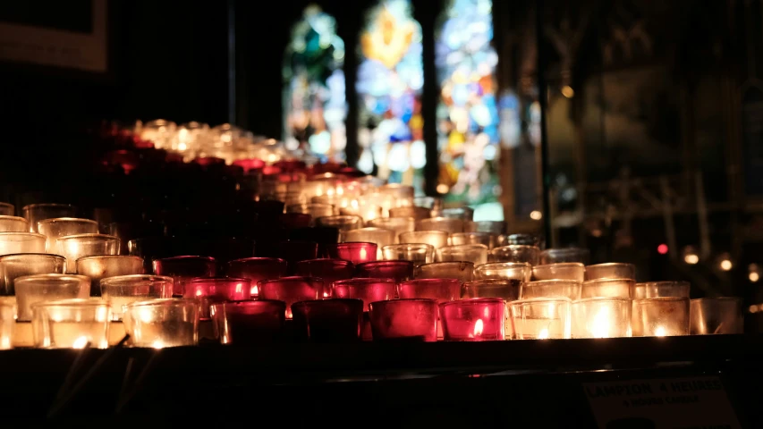 lit candles sitting on top of a church pew