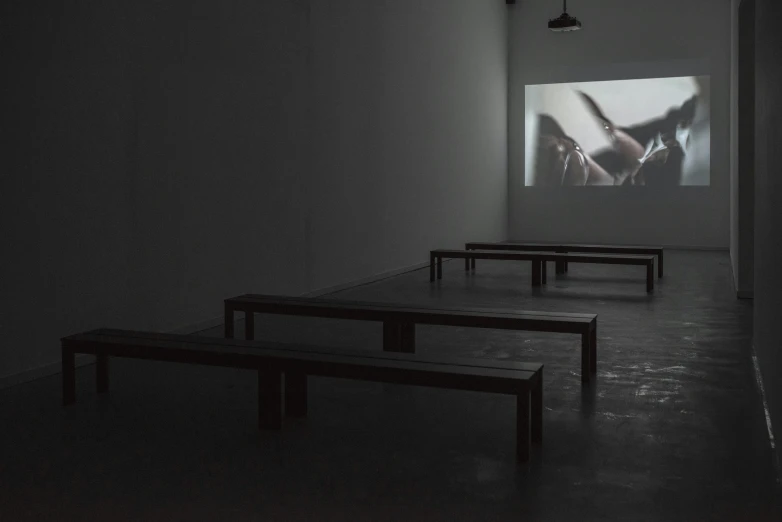 two benches and a projection in an empty room