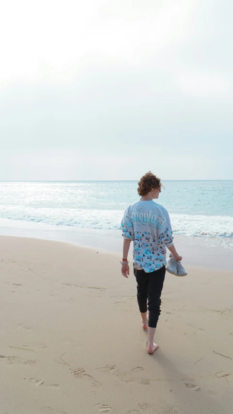 a person walking on the beach with a book