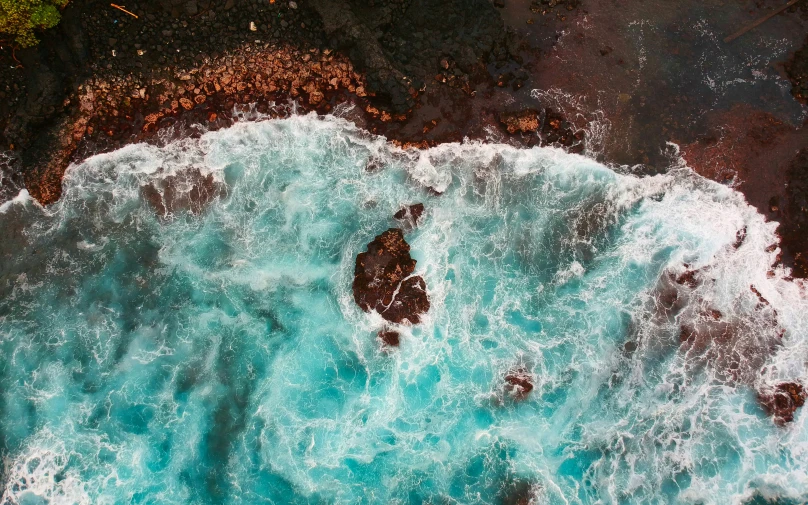 the ocean with foamy water is seen from above