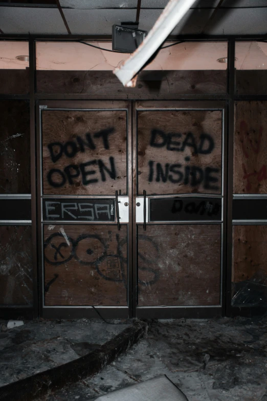 two doors are opened with graffiti and no windows