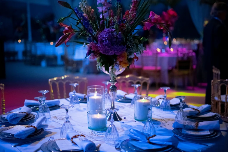 a table set with some silverware and a vase filled with flowers